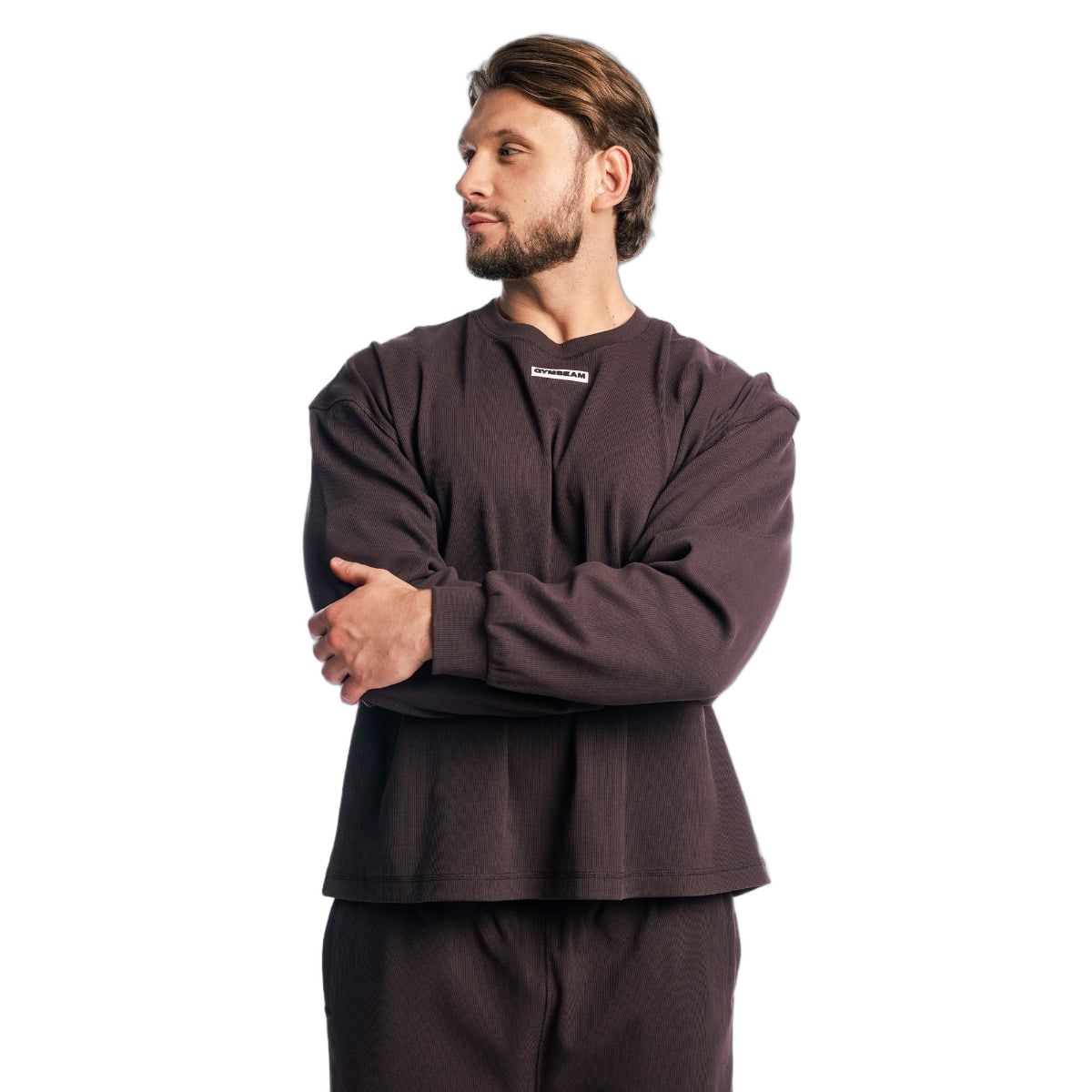 Felpa oversize da uomo in Tee Brown, di lato con braccia incrociate.