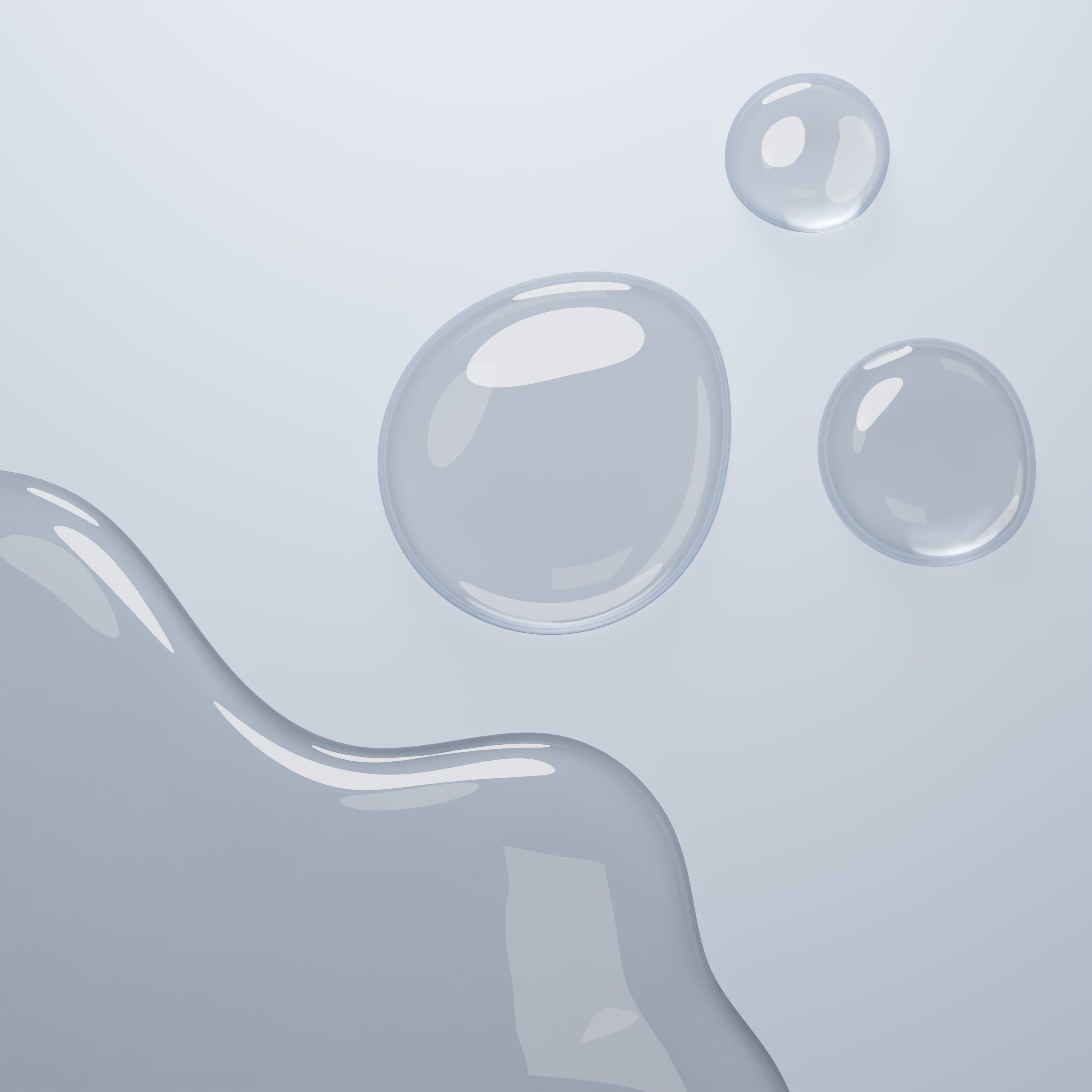 Tre gocce di liquido su sfondo chiaro. Due piccole e una grande goccia.