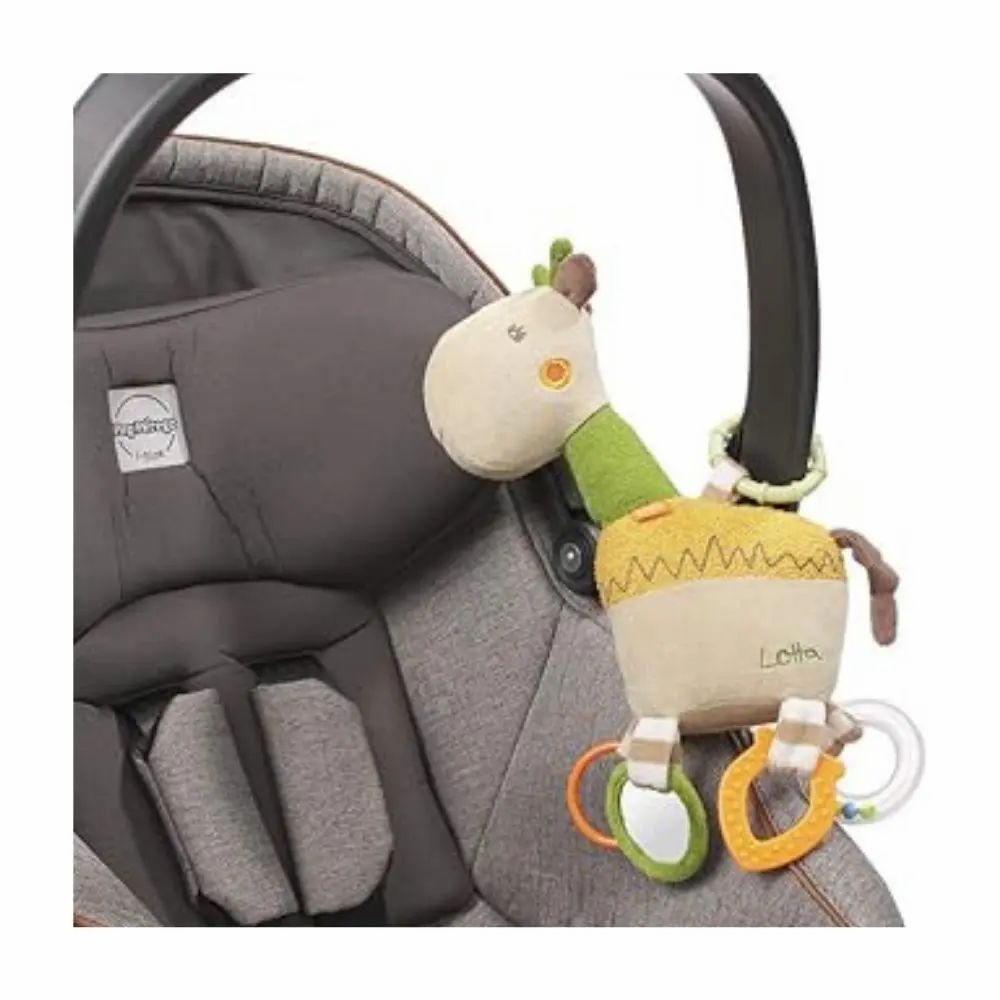 Peluche a forma di giraffa attaccato a un passeggino. Beige, verde e giallo. Anelli e specchi. Scritta "Lotta".