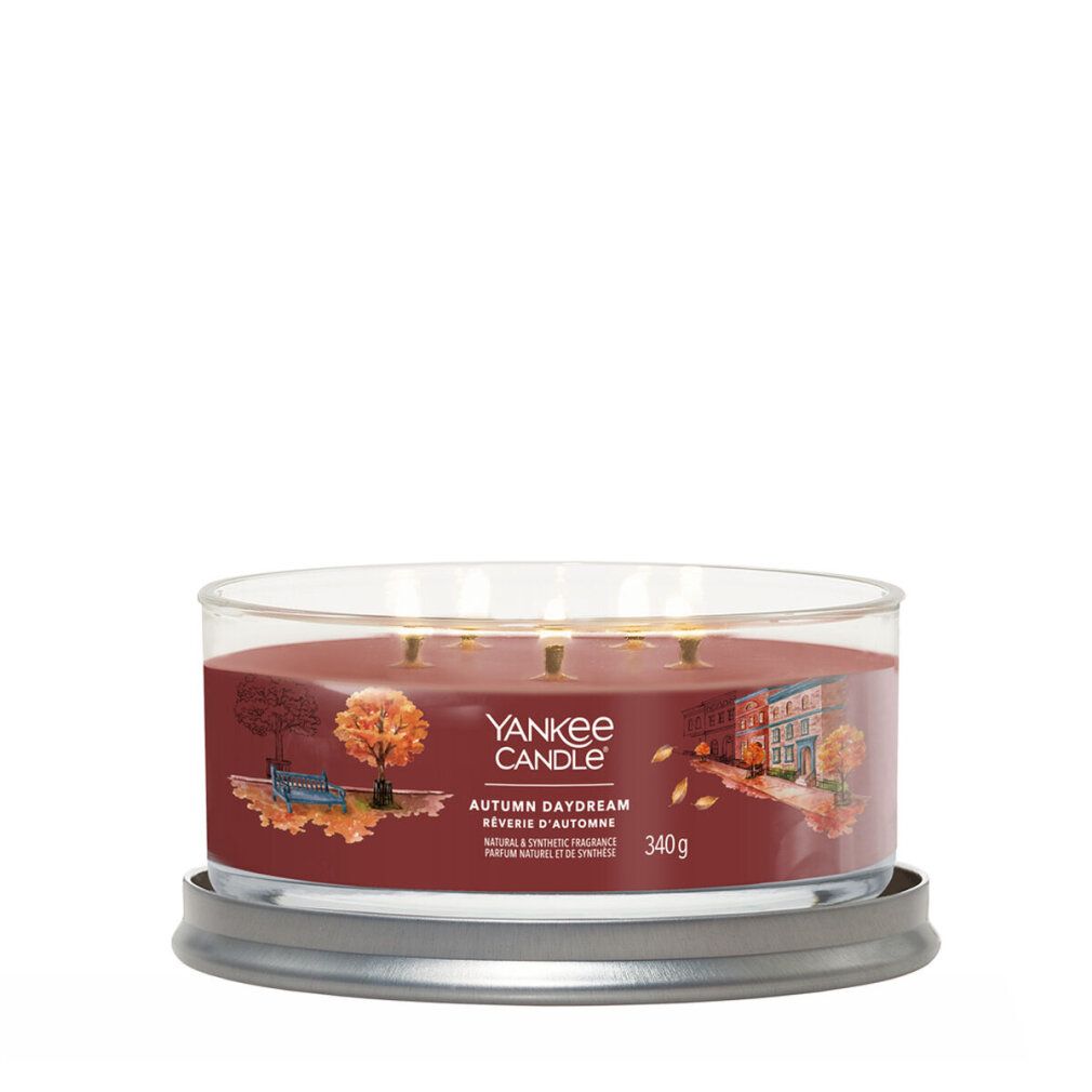 Candela rotonda in vetro. Cera marrone, tre stoppini. Scritta: Yankee Candle, Autumn Daydream. 340g.
