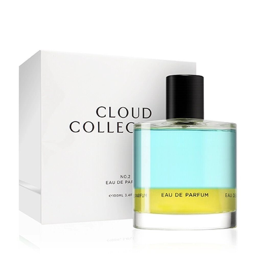 Flacone di profumo con liquido azzurro e giallo, accanto a scatola bianca con scritta "CLOUD COLLECTION".