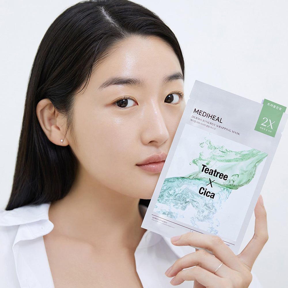 Donna tiene confezione di maschera per il viso. Scritta: MEDIHEAL, Teatree X Cica. 2X. Confezione bianca.
