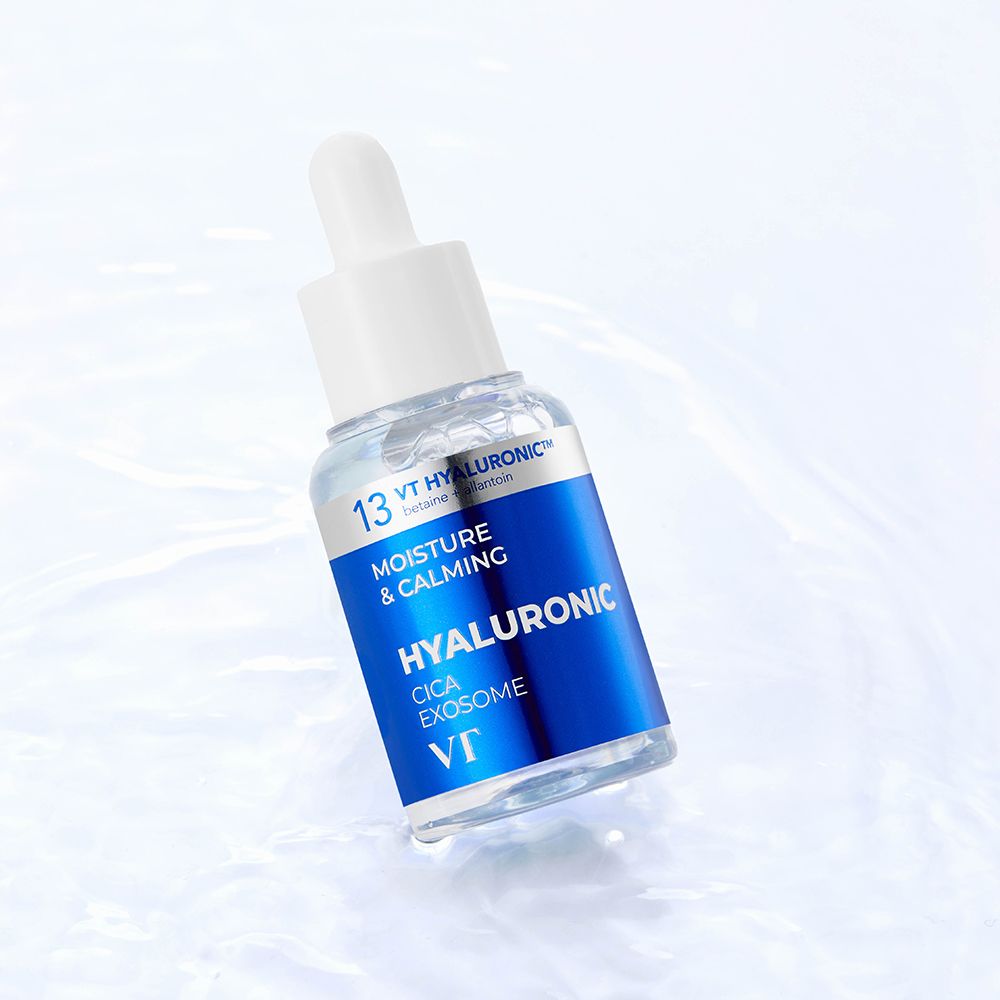 Flacone di siero con etichetta blu. Testo: Hyaluronic Cica Exosome, VT. Sull'acqua. Sfondo bianco.