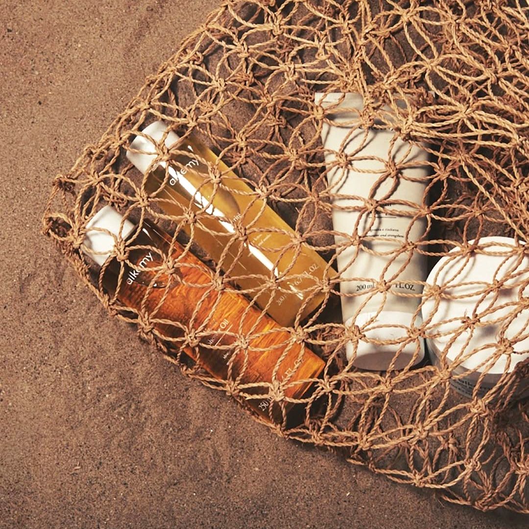 Una borsa con prodotti Alkemy sulla spiaggia.