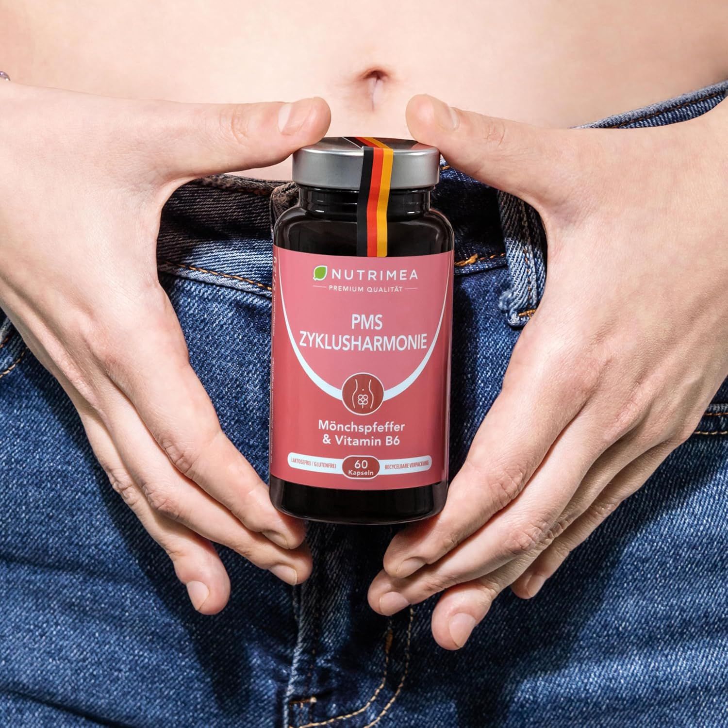 Mani che tengono un flacone PMS ZyklusHarmonie. Scritta: Agnocasto & Vitamina B6. 60 capsule. Con bandiera tedesca.