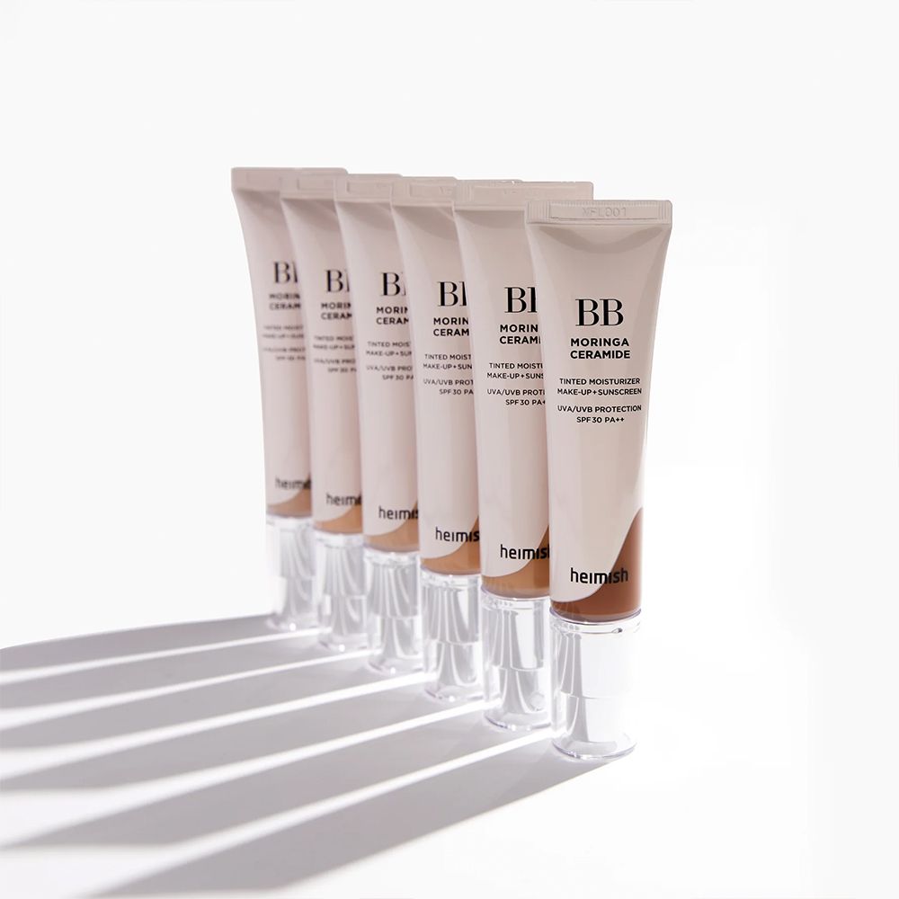 Fila di tubetti di BB cream BB Moringa Ceramide disposti su una superficie bianca.