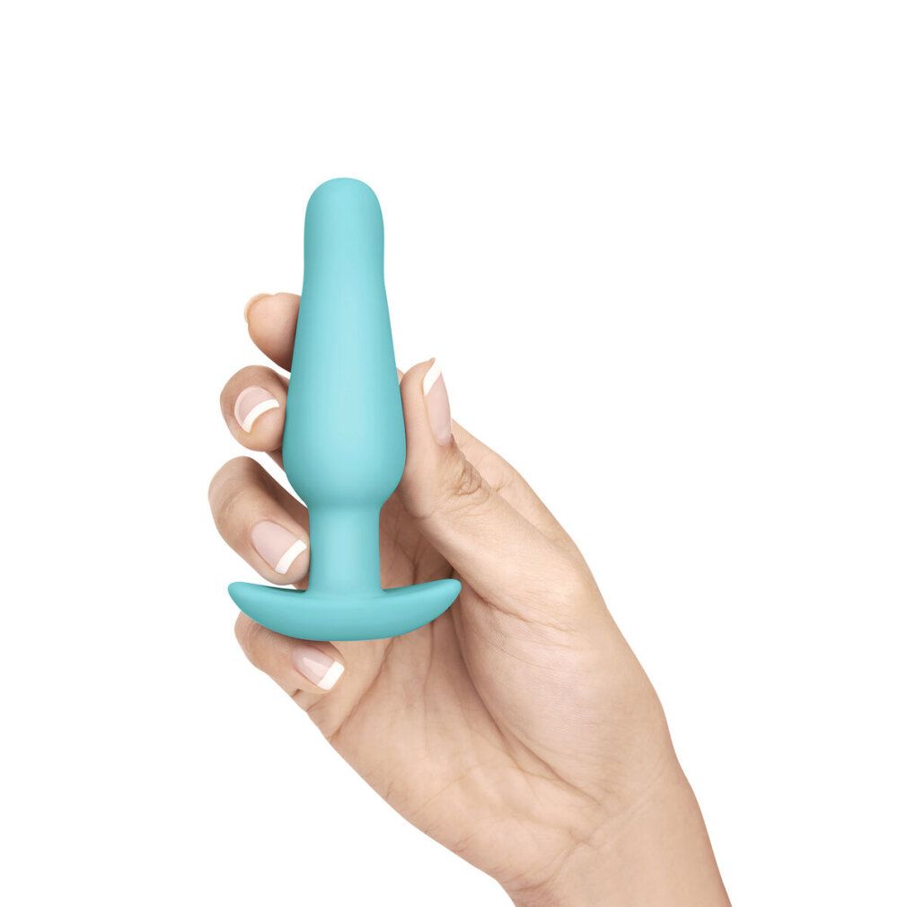 Plug anale turchese tenuto in mano. Forma conica con base ampia.