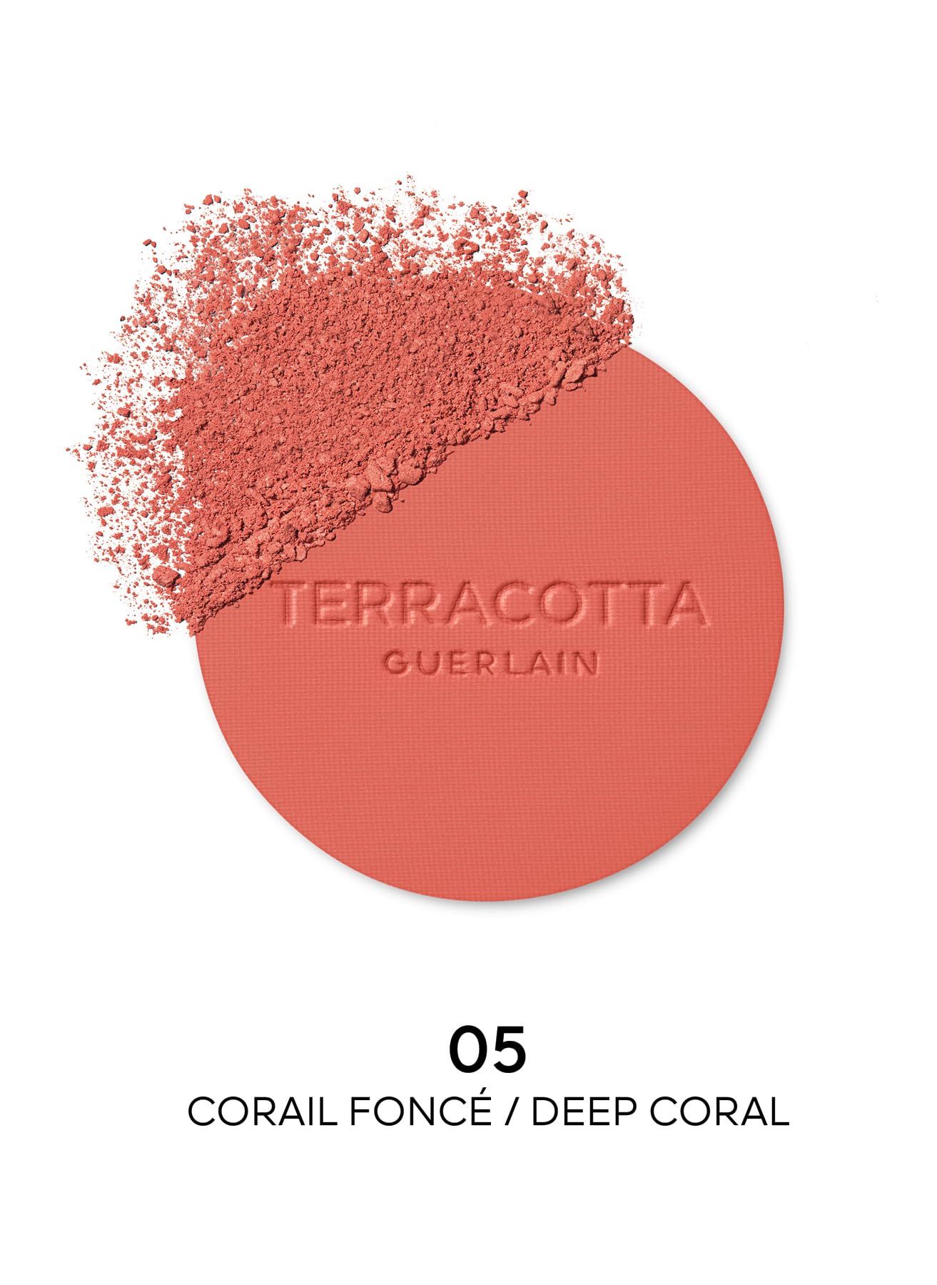 Cipria rotonda con la scritta "TERRACOTTA GUERLAIN". Un po' di cipria è sparsa accanto. Testo: "05 CORAIL FONCÉ / DEEP CORAL".