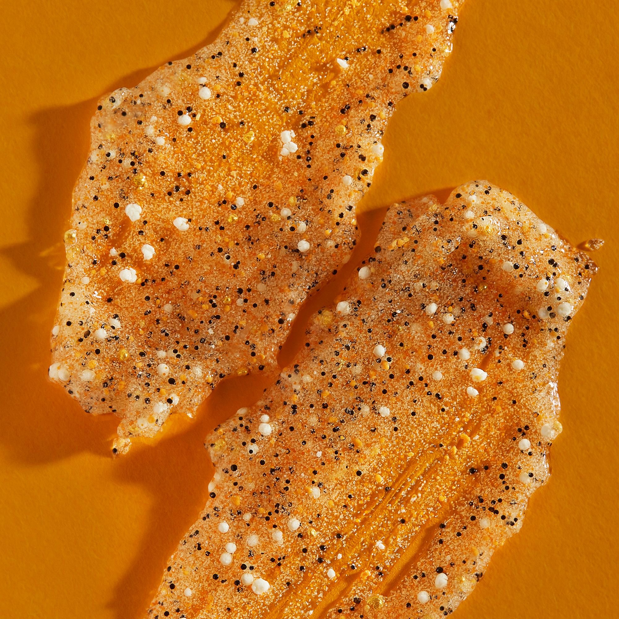 Due pezzi esfolianti arancioni con particelle bianche e nere. Su sfondo arancione.