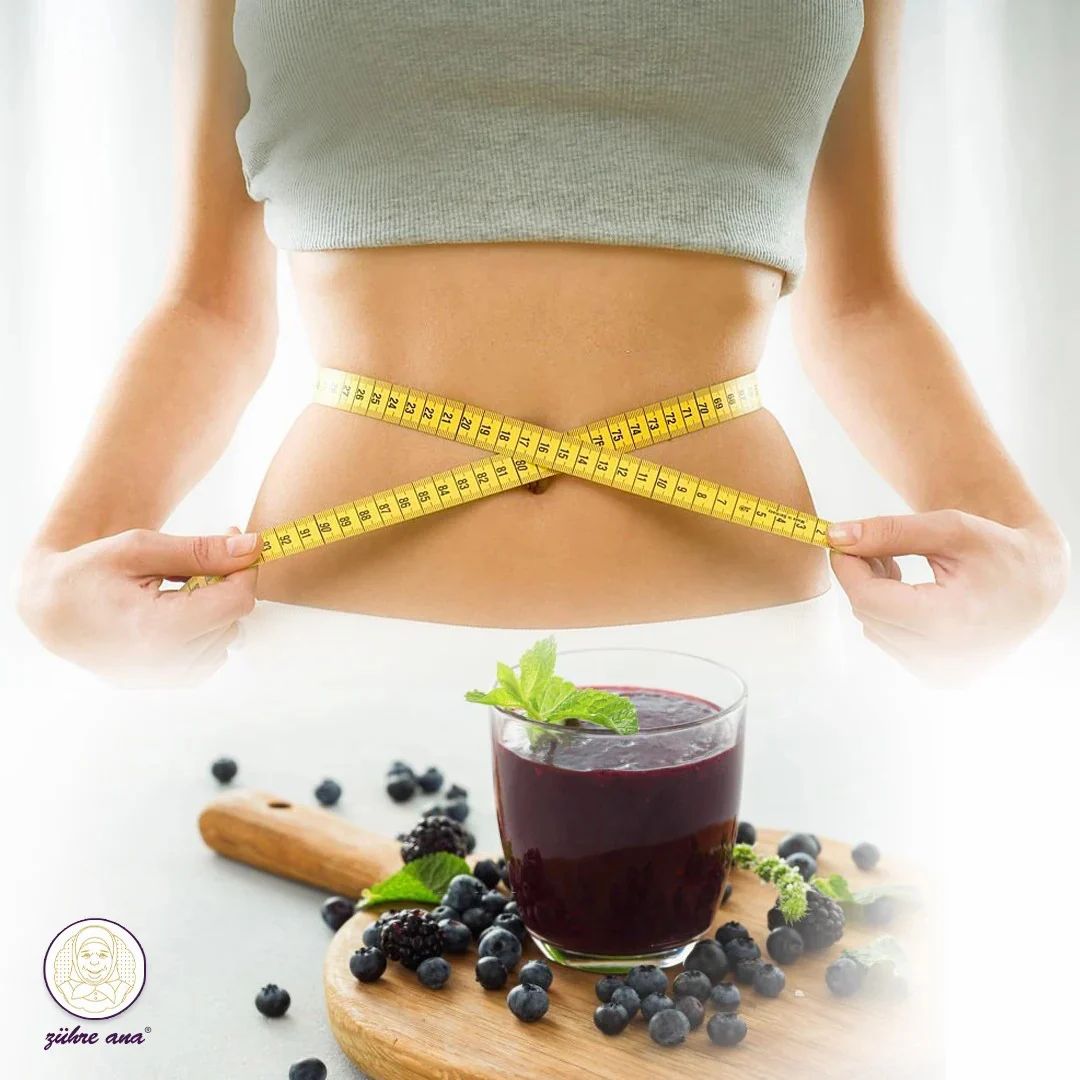 Donna con metro intorno alla vita. Bicchiere di frullato e bacche su tagliere.