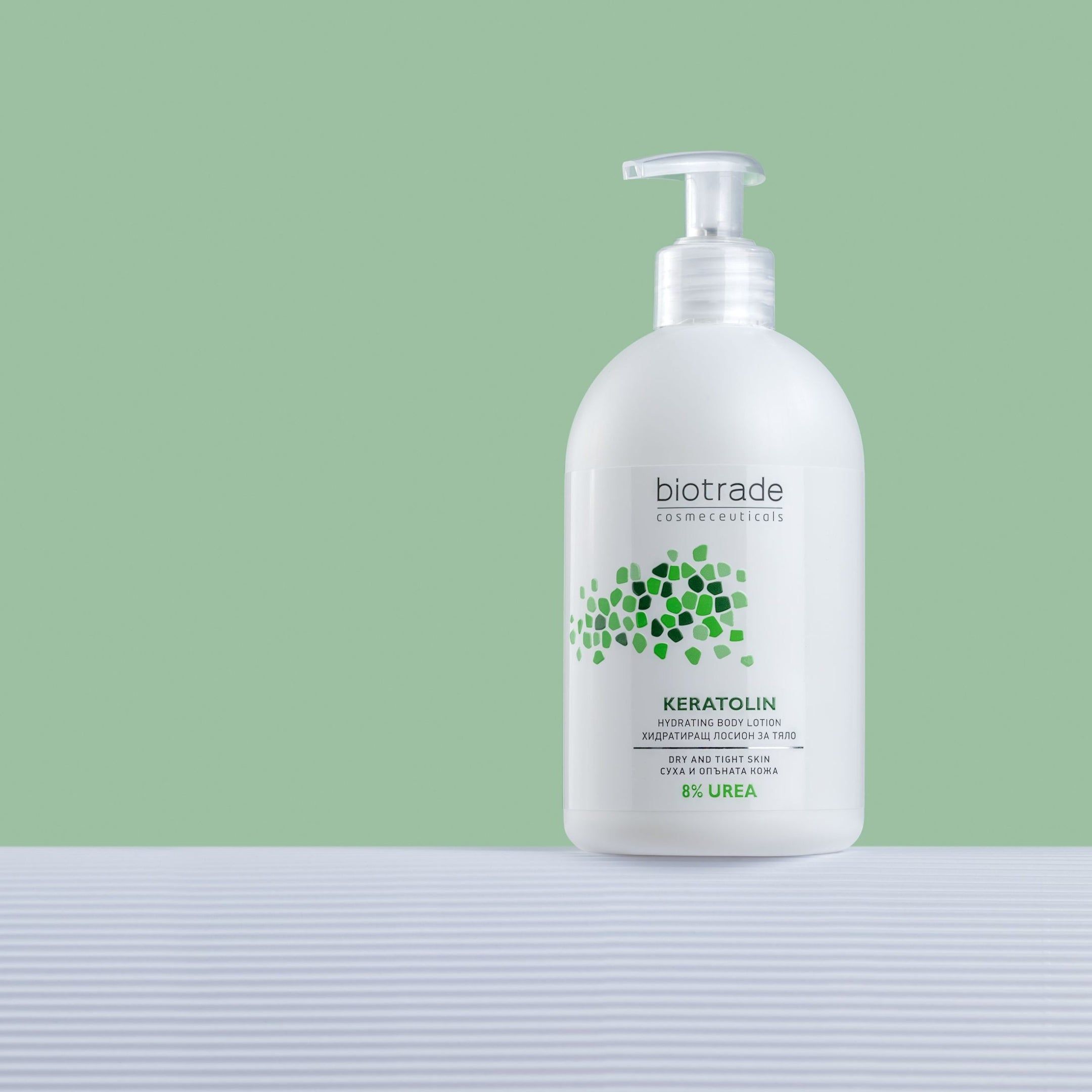 Flacone bianco con dosatore. Biotrade Keratolin Body, 8% Urea. Su sfondo bianco davanti a sfondo verde.
