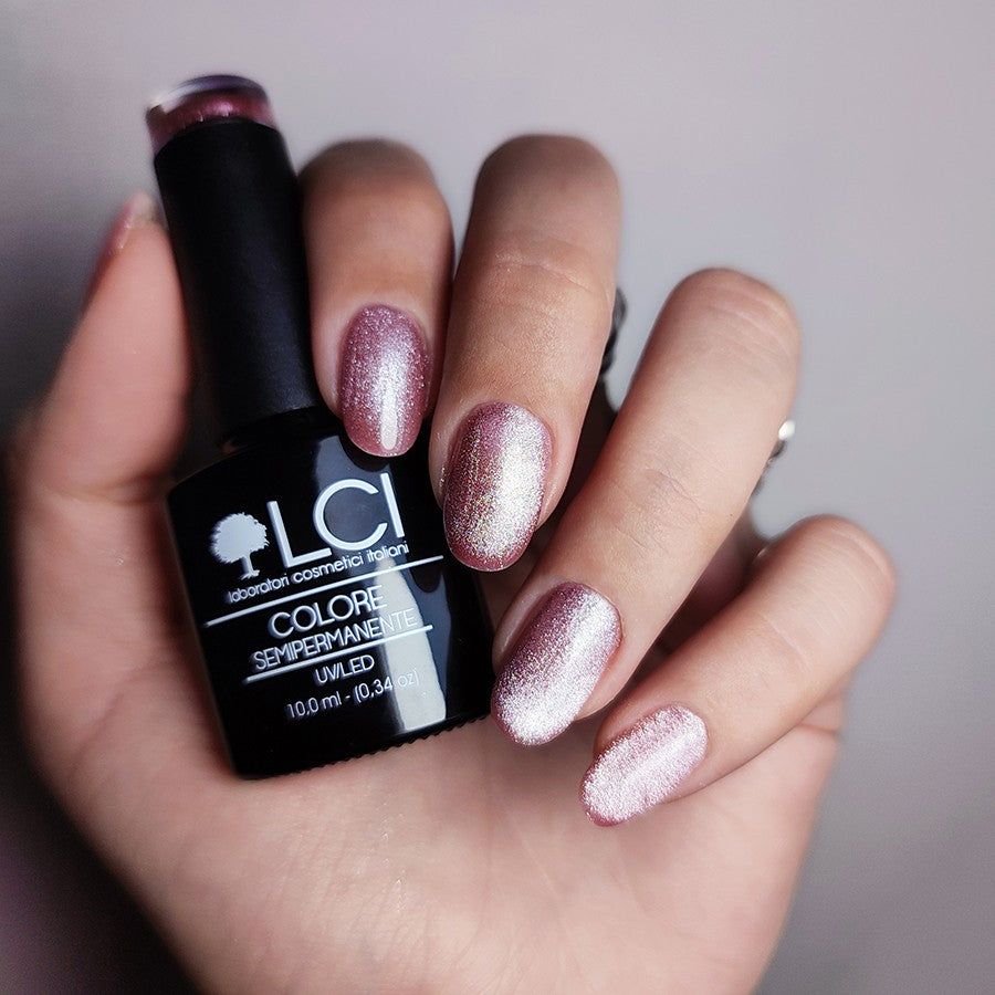 Mano con unghie smaltate. Colore rosa-marrone con effetto lucido. Flacone con scritta: LCI, Colore Semipermanente, UVLED.