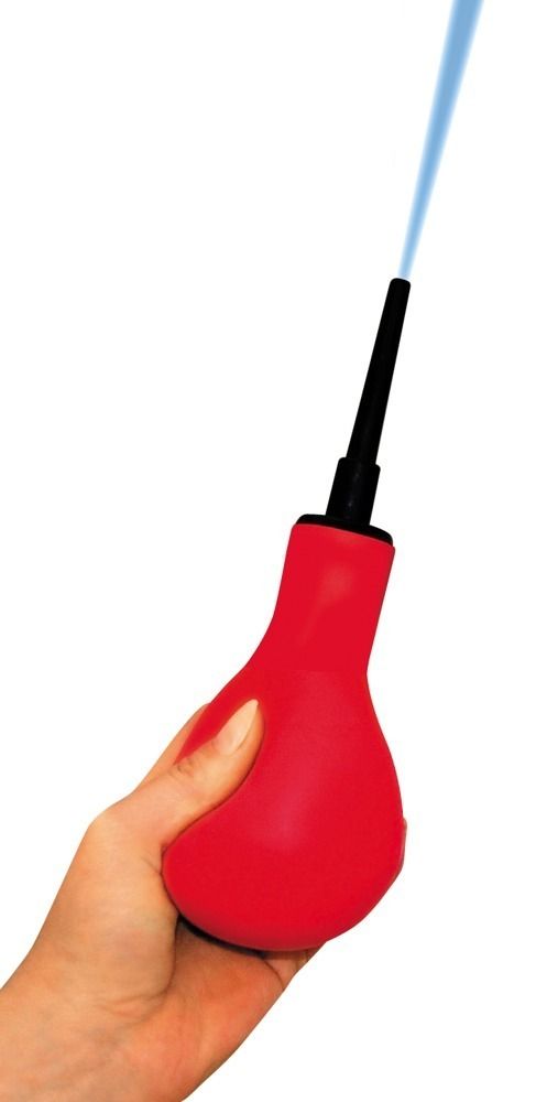 Doccia intima rossa tenuta in mano, con accessorio nero. Getto d'acqua che esce dalla punta.