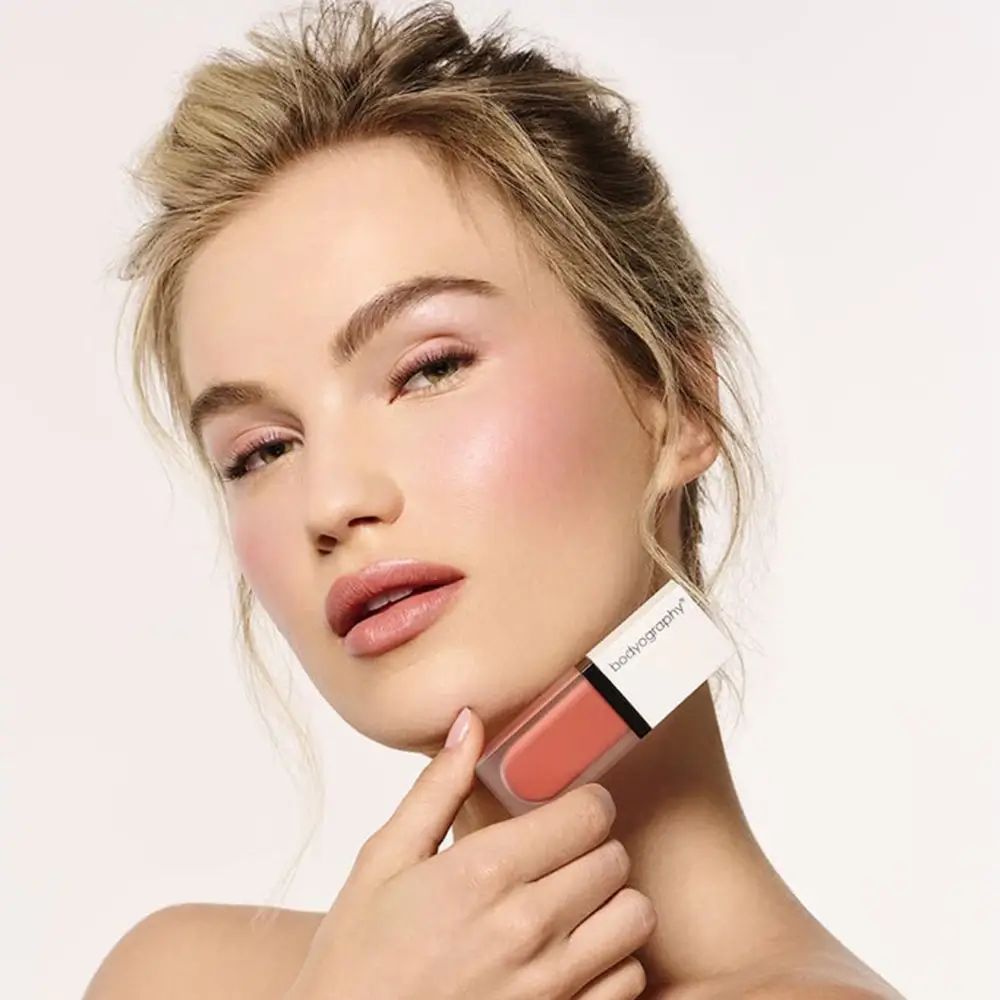 Donna con fard liquido. Flacone trasparente, tappo bianco. Marchio BODYOGRAPHY.