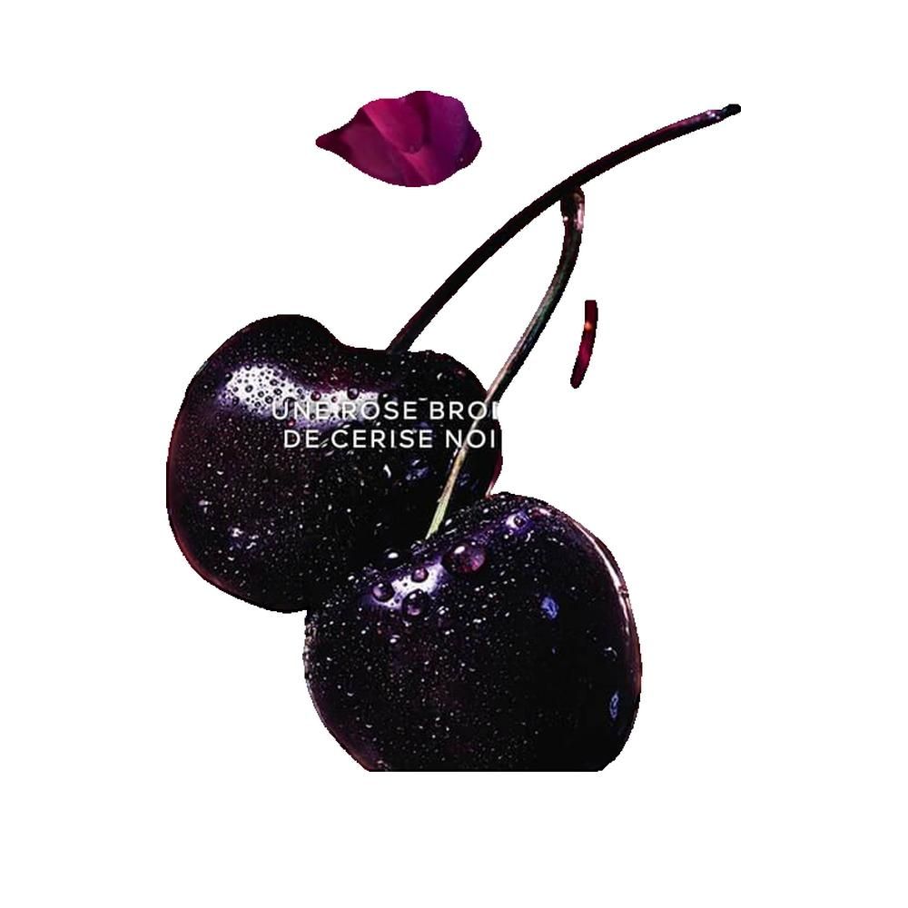 Due ciliegie con gocce d'acqua. Ciliegie nere con gambo e foglia. Testo: Une rose brodée de cerise noire.