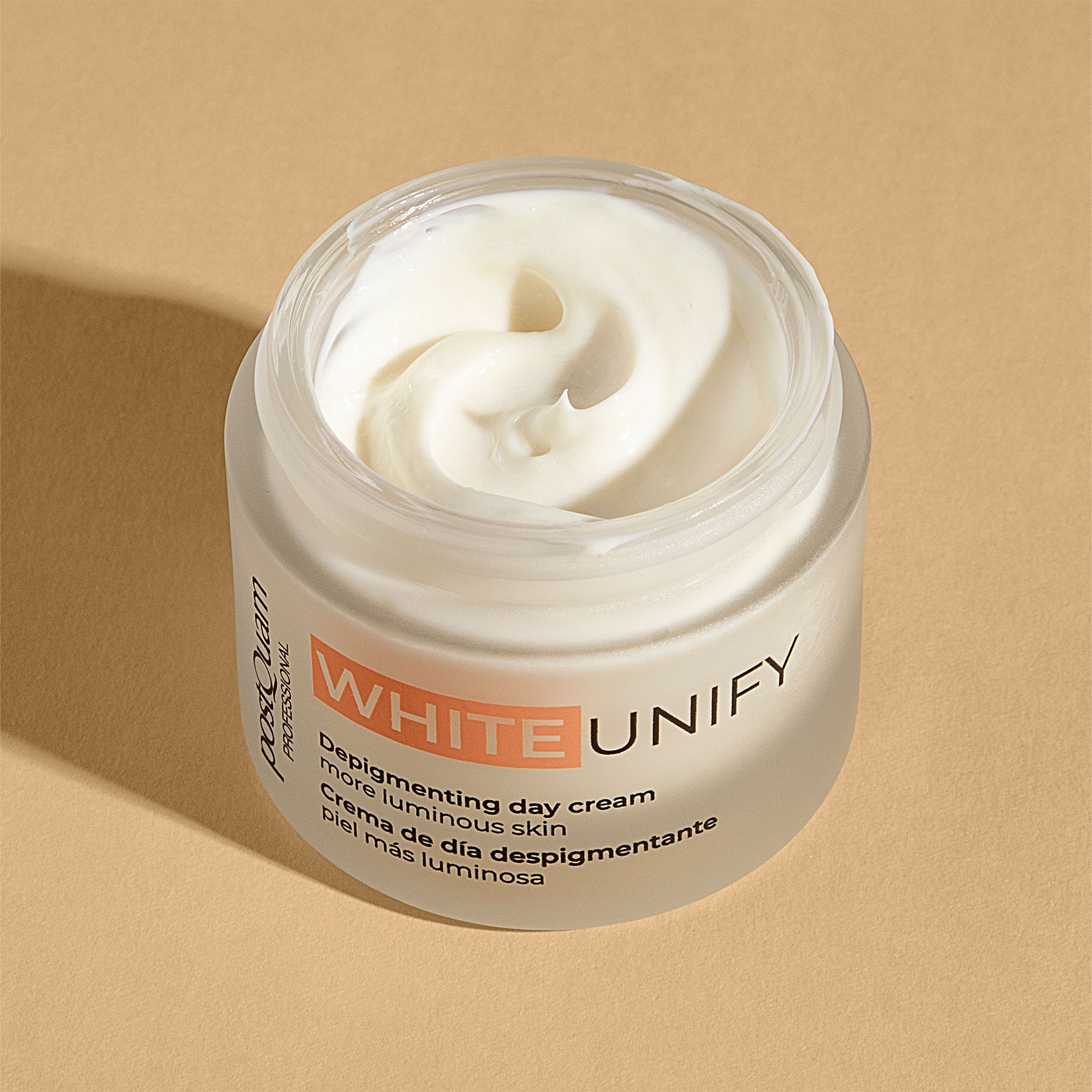 Vaso di crema aperto. Crema bianca visibile. Scritta WHITE UNIFY, Depigmenting day cream, pelle più luminosa. Marchio Postquam.