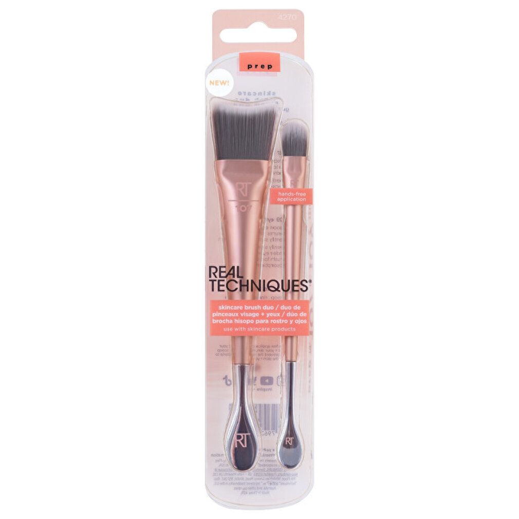 Pennello trucco doppio in confezione. Manici oro rosa, setole grigie. Testo: 'REAL TECHNIQUES' e 'PREP'.