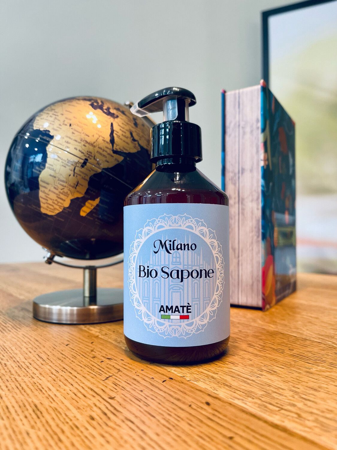 Flacone marrone con dosatore nero. Etichetta "Milano Bio Sapone" e "Amatè".