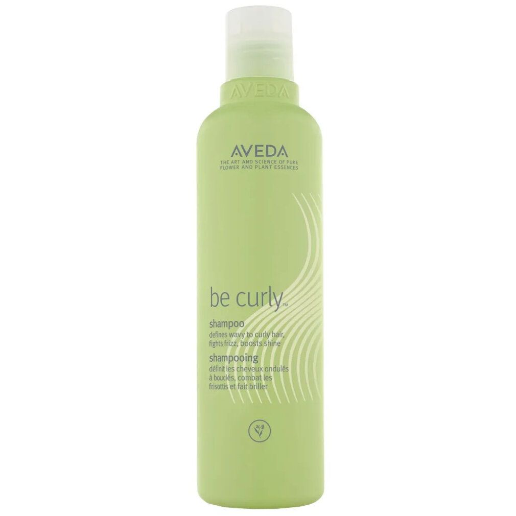 Aveda Be Curly Shampoo. Flacone verde con etichetta bianca. Nome del prodotto e logo visibili.