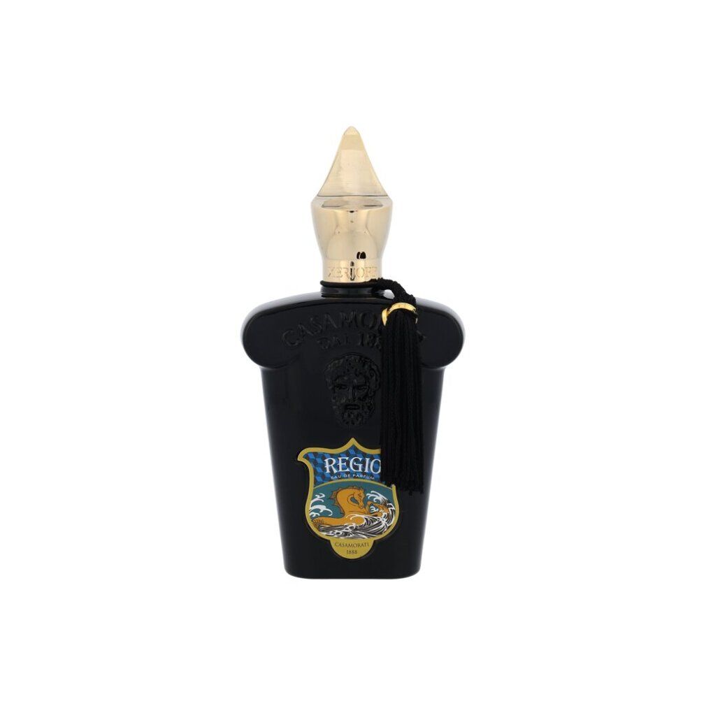 Flacone nero con tappo dorato e nappa. Testo: Regio, logo.