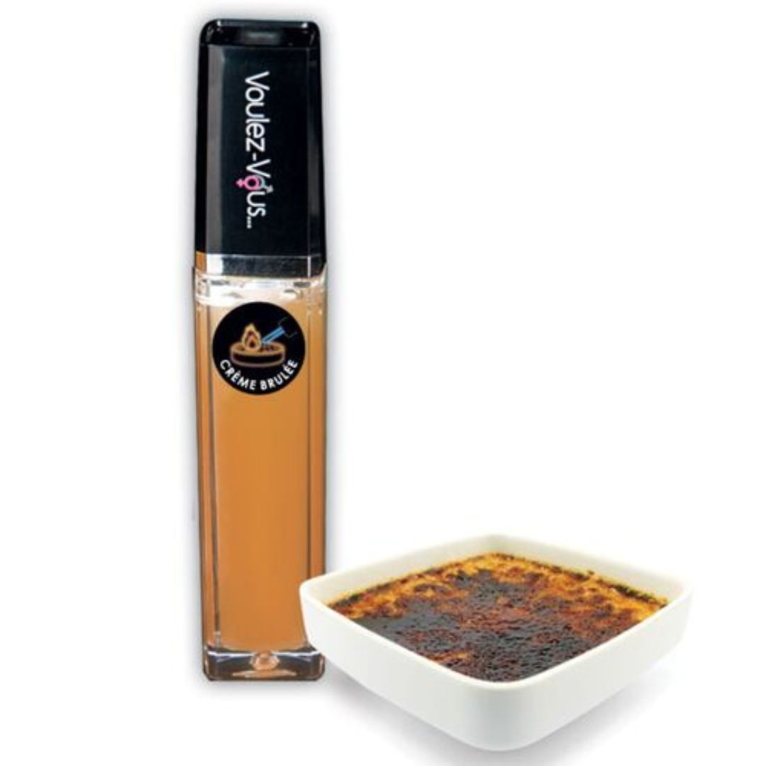 Lucidalabbra in custodia trasparente con tappo nero. Scritta: Voulez-Vous. Etichetta: Crème Brûlée. Accanto: Crème brûlée in ciotola.