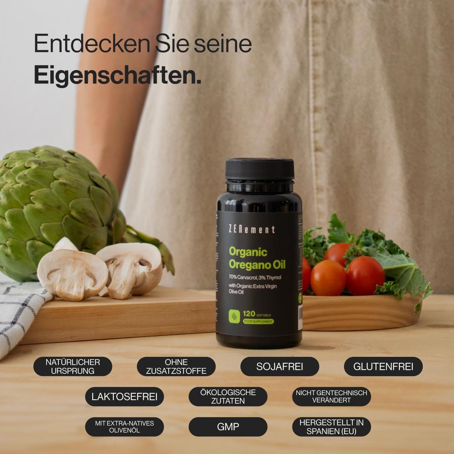 Flacone nero di capsule di olio di origano BIO Zenement. Scritta: Organic Oregano Oil. Con verdure su superficie in legno.