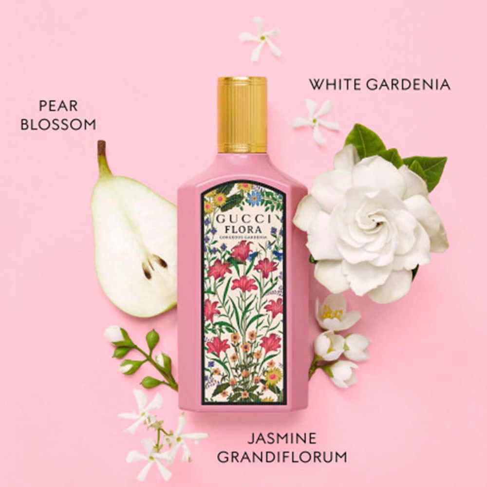 Flacone rosa Gucci Flora con tappo dorato. Fiori di gardenia bianca, pera e gelsomino. Testo: Pear Blossom, White Gardenia, Jasmine Grandiflorum.