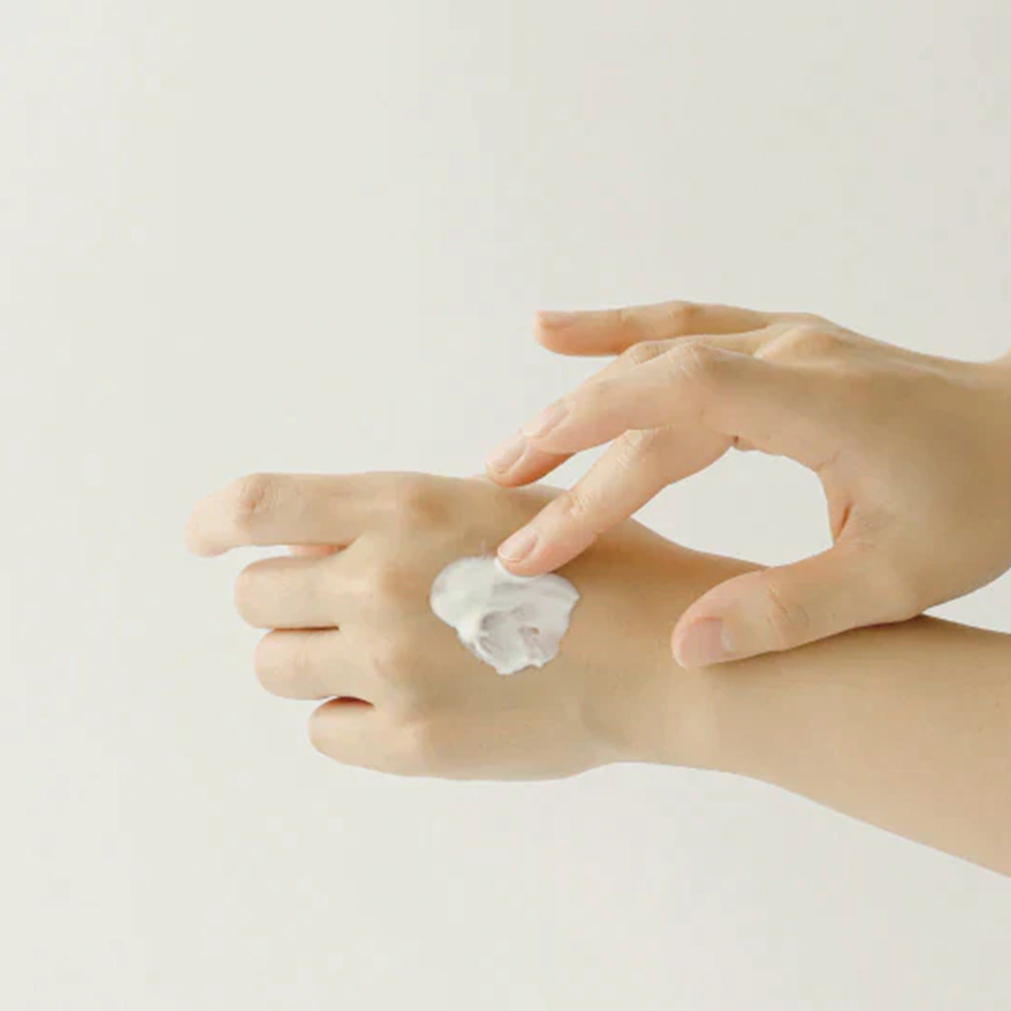 Mani che applicano la crema sulla pelle. Crema sul palmo.