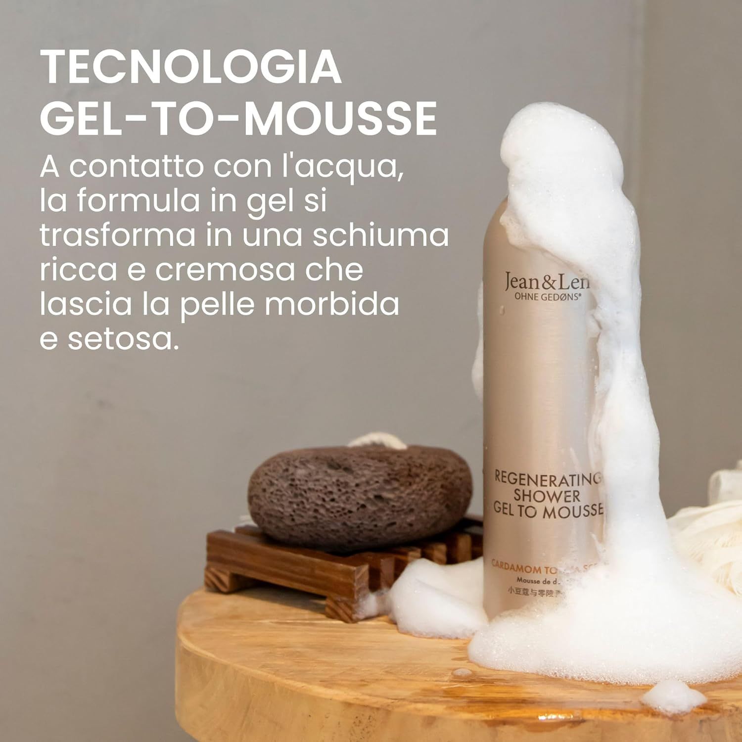 Flacone beige con tappo bianco. Schiuma che fuoriesce. Testo: Jean & Len, Regenerating Shower Gel To Mousse.