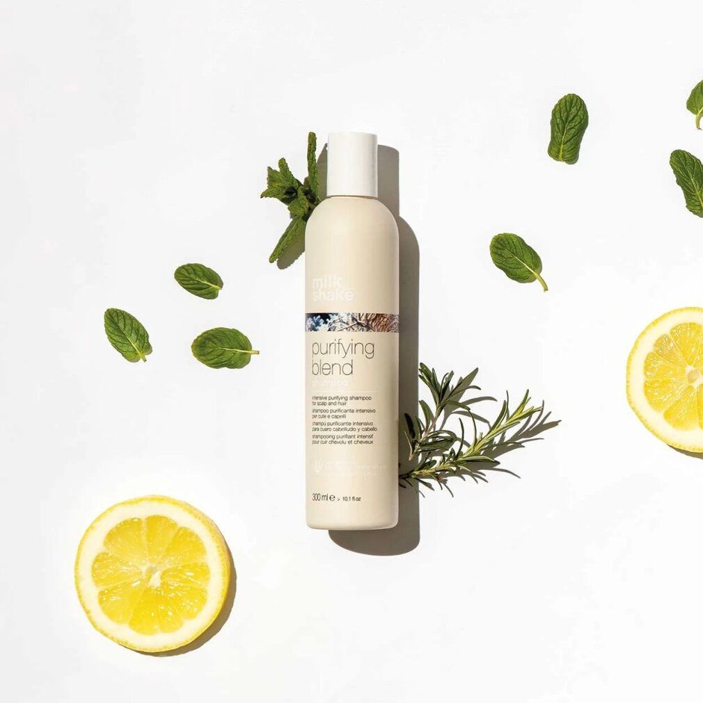 Flacone di shampoo beige con tappo bianco, circondato da erbe e limoni. Scritta: purifying blend. Testo sottostante: intensive purifying shampoo. In basso: 300 ml.