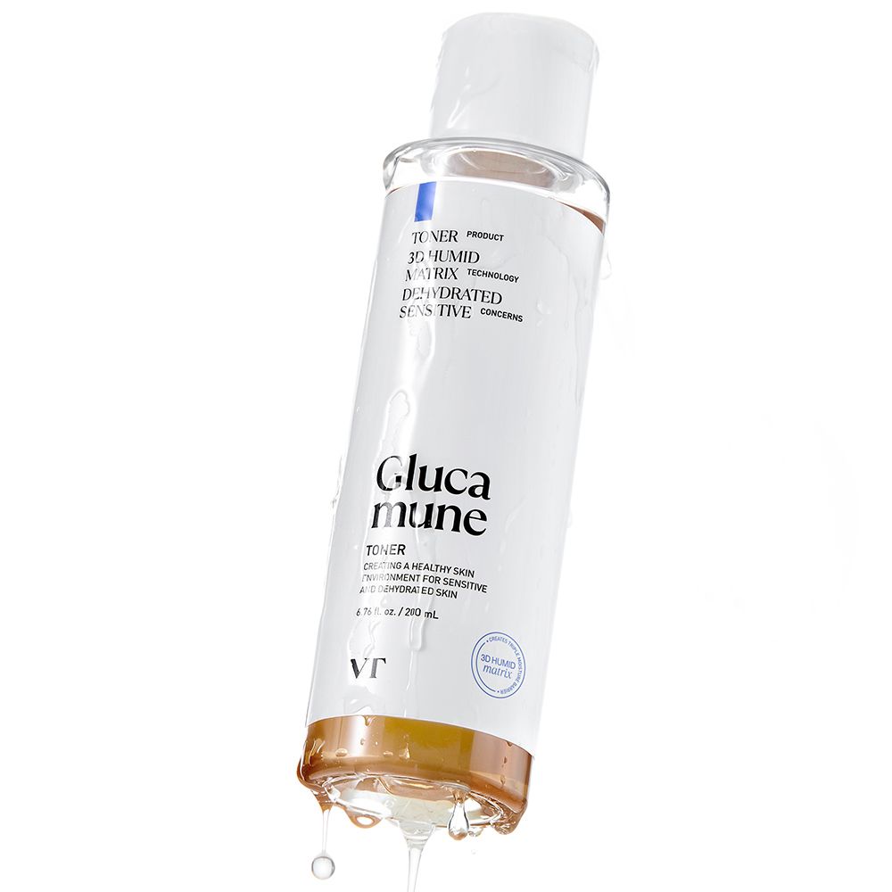Flacone trasparente con tappo bianco. Scritta: Glucamune Toner. Liquido che gocciola dall'apertura.