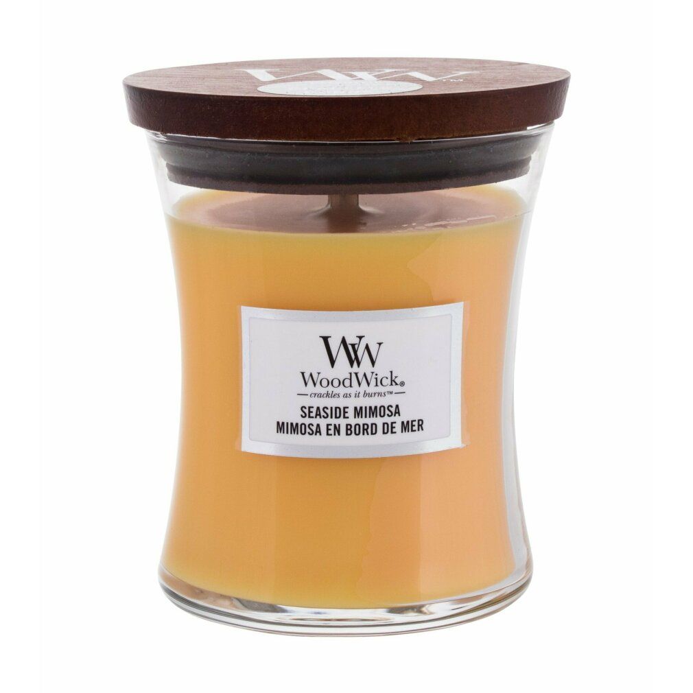 Candela a forma di clessidra con coperchio in legno. Cera gialla, etichetta "WoodWick Seaside Mimosa".