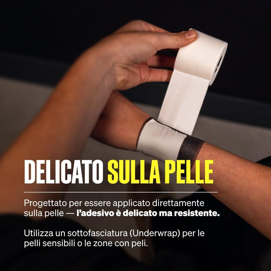 Una persona applica nastro bianco di ossido di zinco su un avambraccio. Delicato sulla pelle e forte adesione.
