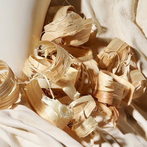 Primo piano di riccioli di legno su tessuto chiaro. Riccioli di varie dimensioni e forme, marroni e beige.