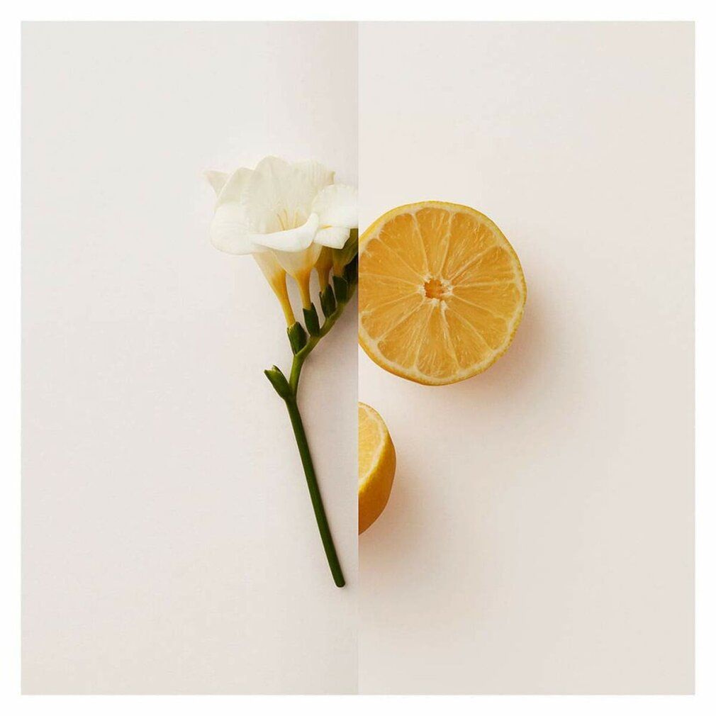 Su sfondo diviso: fiore di fresia e metà limone.
