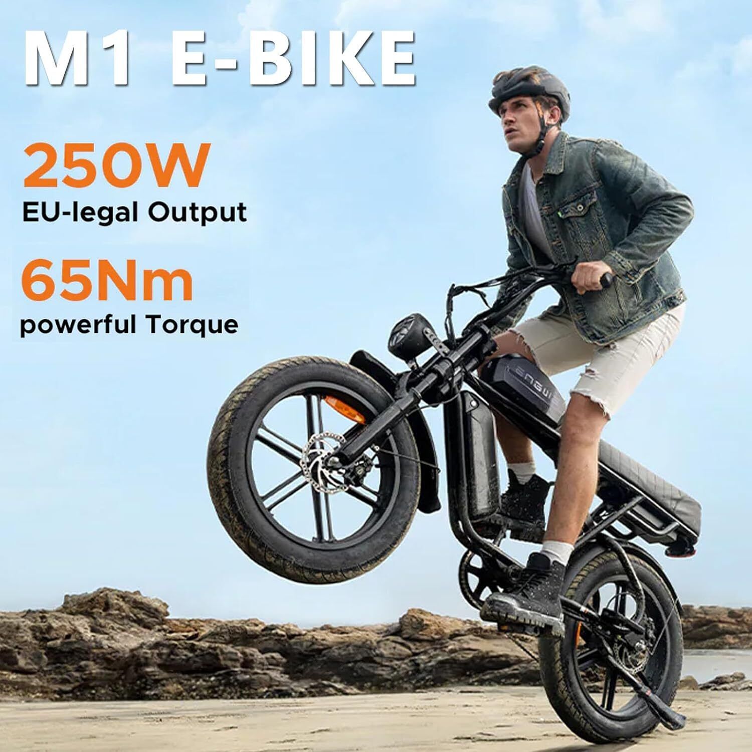 E-bike nera sulla sabbia. Testo: "M1 E-BIKE 250W EU-legal Output 65Nm powerful Torque". Una persona guida la bici.