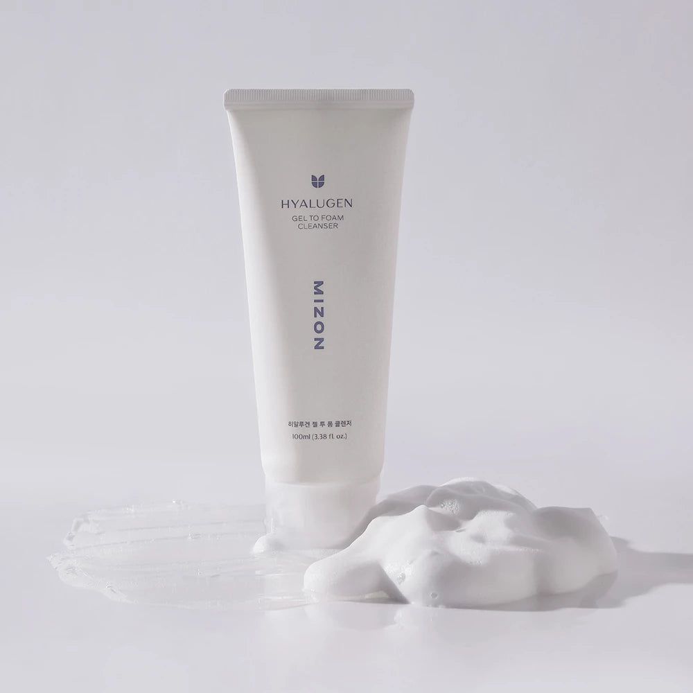 Tubo bianco con prodotto e schiuma. Scritta HYALUGEN, GEL TO FOAM CLEANSER, MIZON. Schiuma accanto.