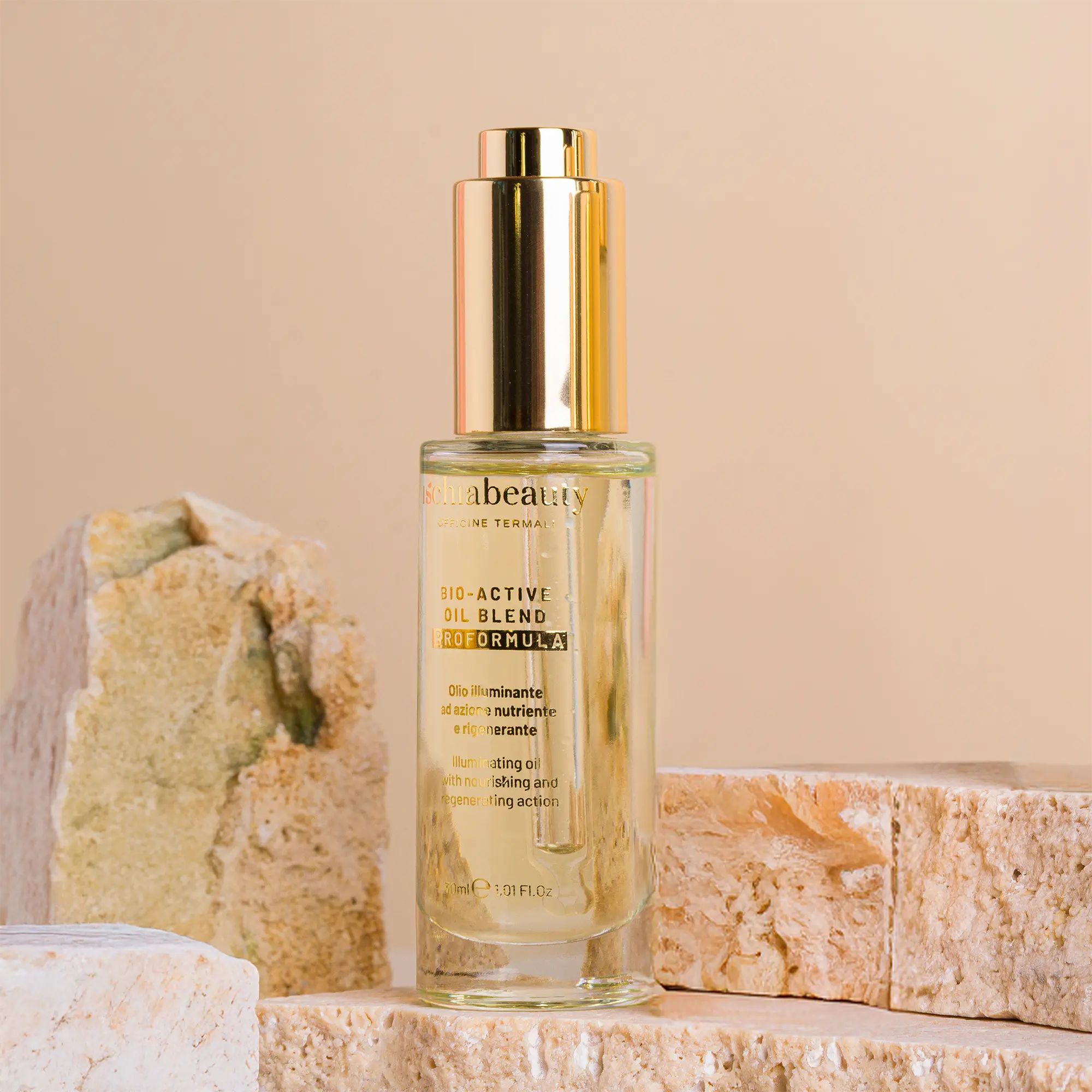 Flacone in vetro con pipetta dorata. Scritta: ischiabeauty, BIO-ACTIVI OIL BLEND. Posizionato su pietre.