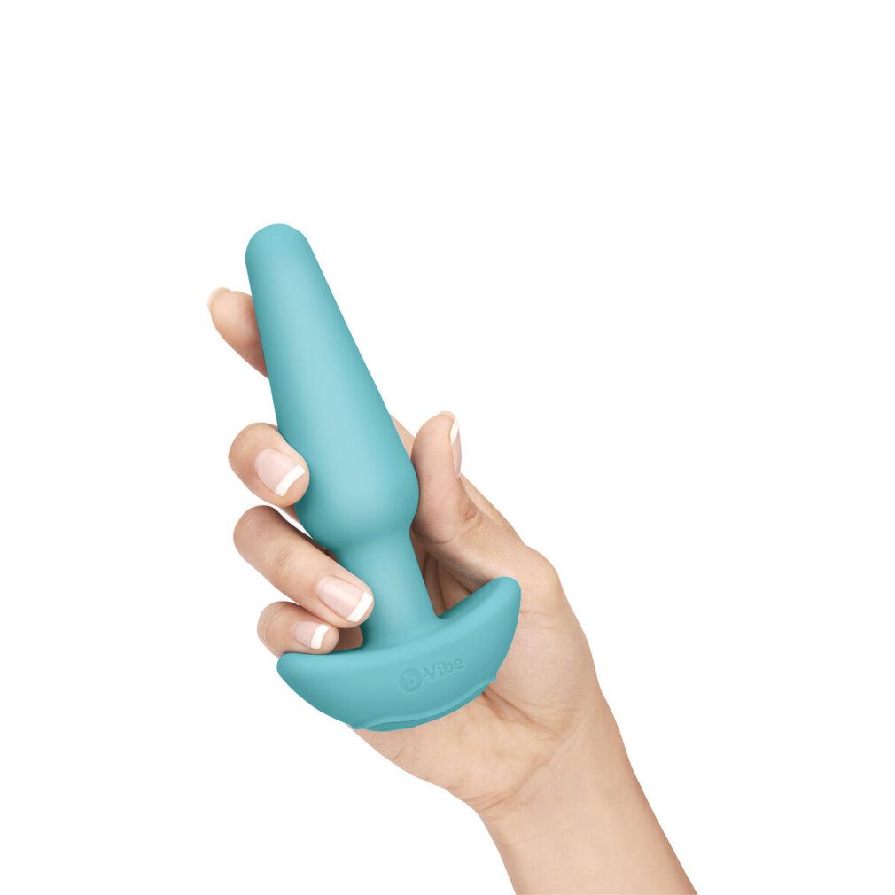 Plug anale turchese tenuto in mano. Forma conica con base ampia.
