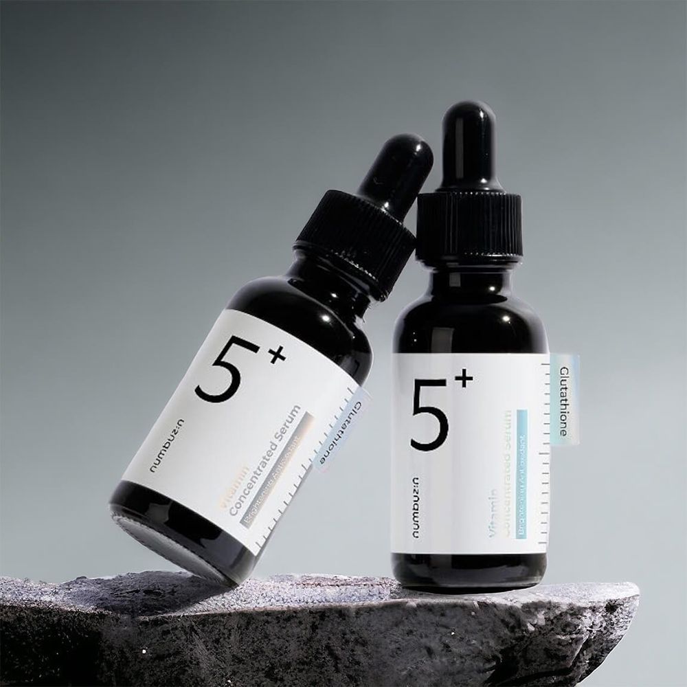 Due flaconi neri con pipette. Etichetta con testo: Vitamin Concentrated Serum, Glutathione. Scritta: 5+.