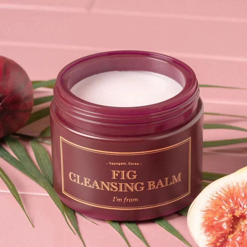 Vasetto rosso scuro con balsamo bianco. Scritta: FIG CLEANSING BALM, I'm from. Fichi e foglie sullo sfondo.