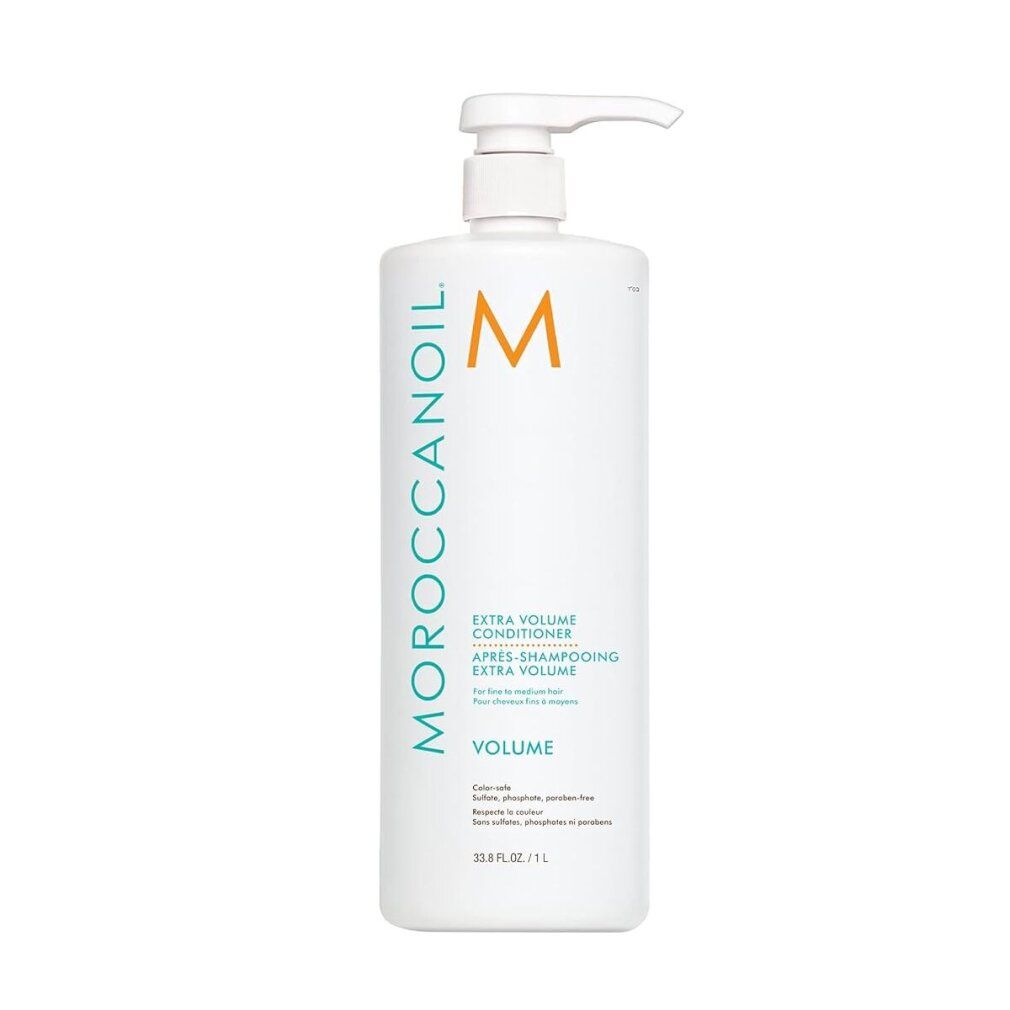Flacone bianco di balsamo con dosatore. Testo: Moroccanoil, Extra Volume Conditioner, Volume. Logo arancione.