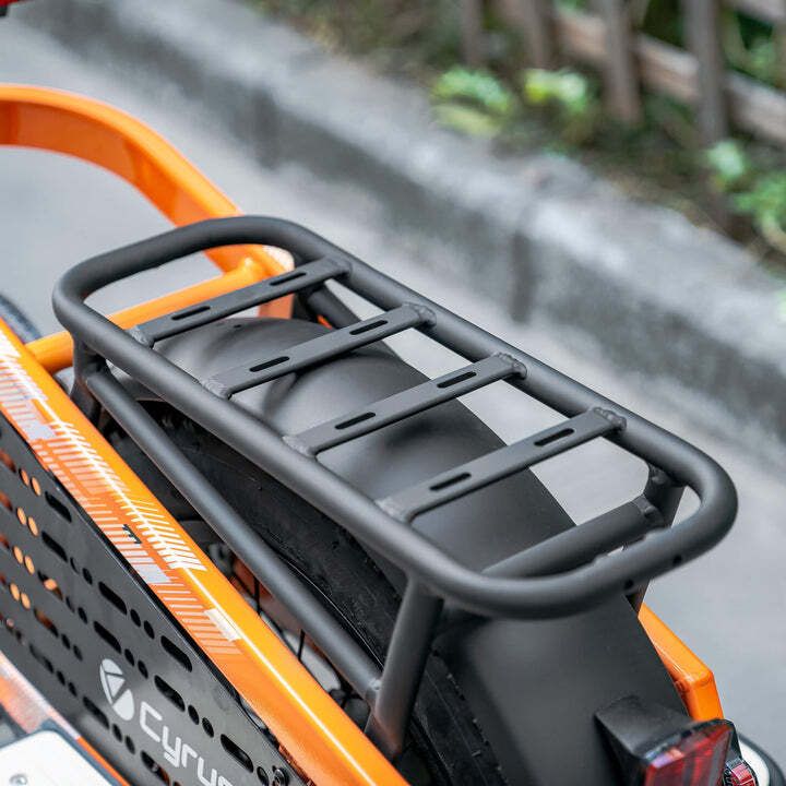 Portapacchi nero su una bicicletta arancione. Forma rettangolare con traverse.