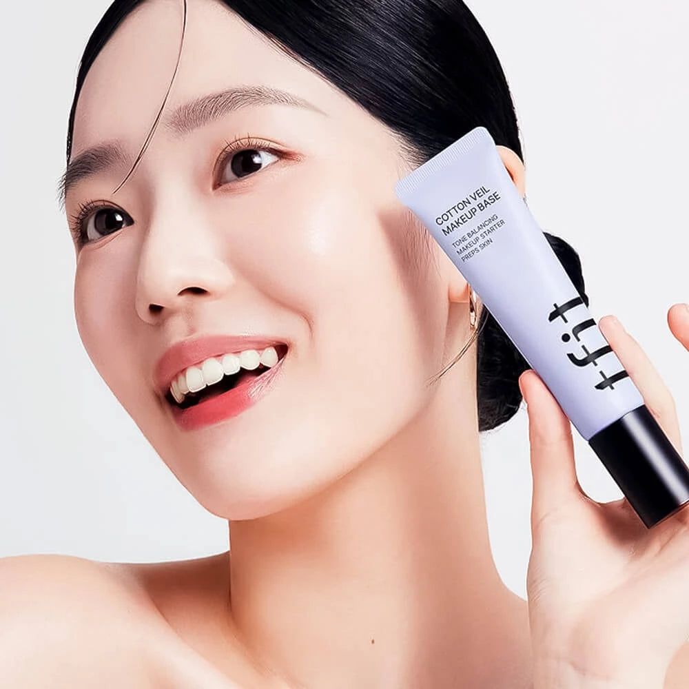 Donna che tiene un tubo di TFIT Cotton Veil Makeup Base Viola Vivace.