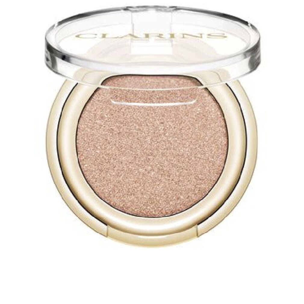 Contenitore rotondo dorato di ombretto con contenuto rosa. Il coperchio trasparente è aperto. Clarins è visibile.