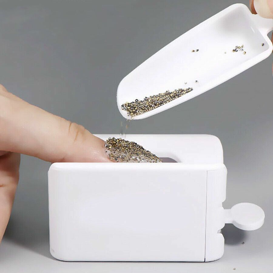 Contenitore bianco rettangolare con scomparti estraibili. Mano che versa glitter nel contenitore.