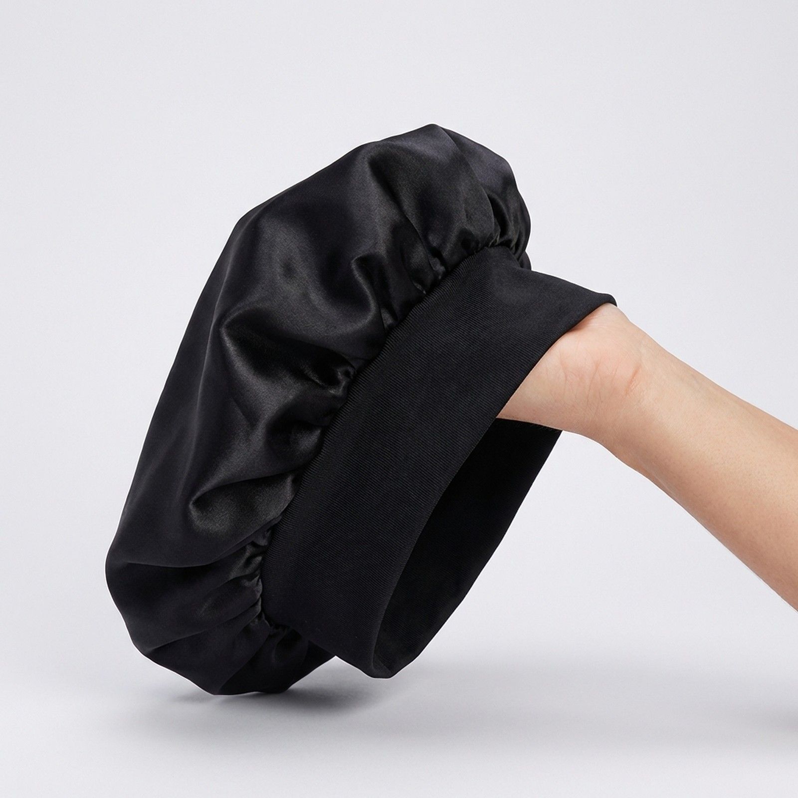 Berretto da notte nero in raso con ampia fascia elastica.