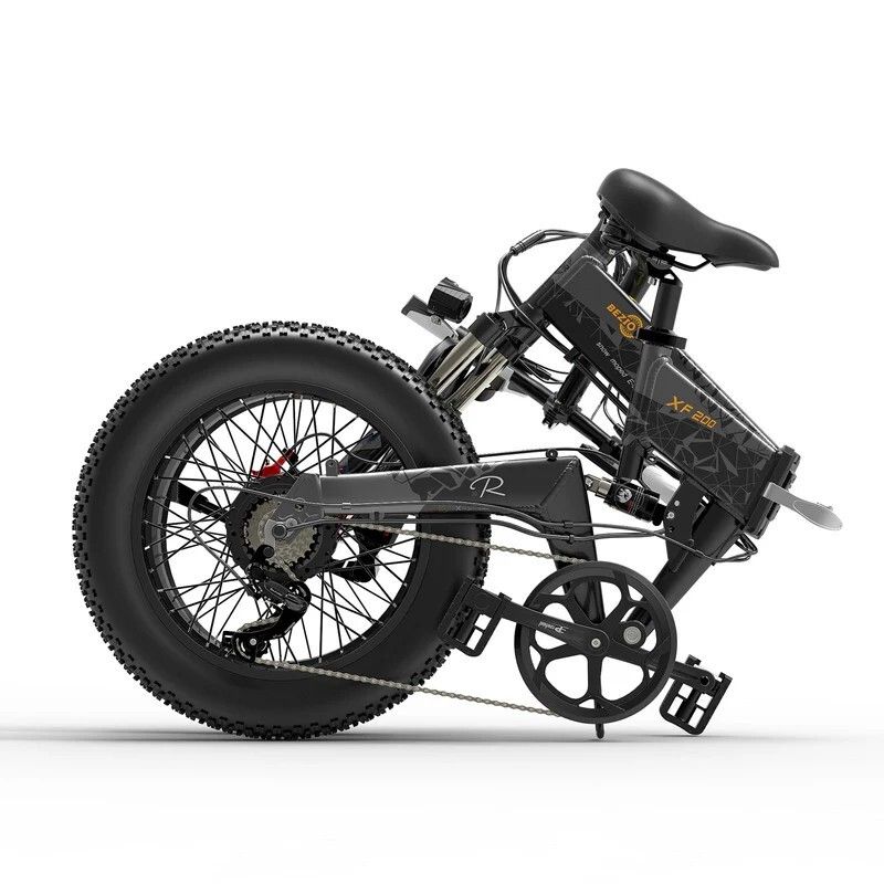 Bicicletta elettrica piegata. Telaio nero, pneumatico largo, sella. Dettagli: catena, disco freno, pedali. Vista laterale.