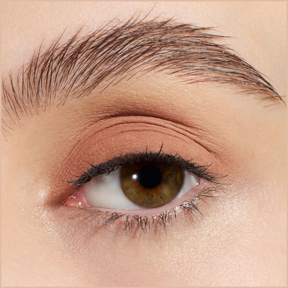 Primo piano di un occhio con ombretto. Il trucco è in una tonalità opaca calda.