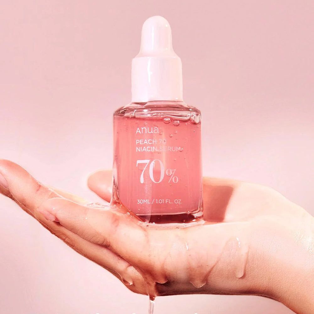 Flacone di vetro con siero in una mano. Scritta: Anua, PEACH 70 Niacin Serum, 70%. 30 ml / 1.01 fl.oz.